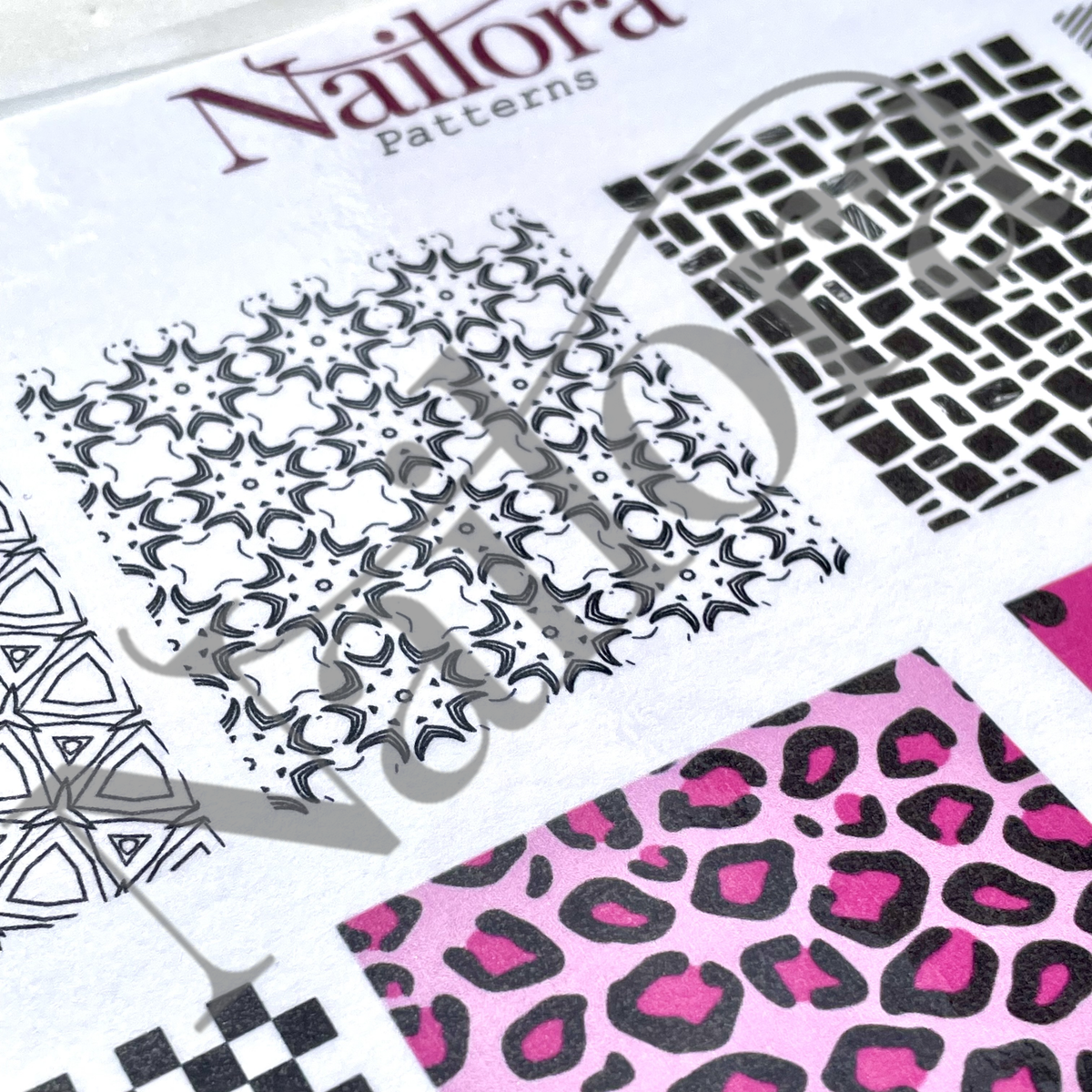 Nailora Patterns nail art stencil sheet showing multiple black and pink geometric and animal print stencil designs on a white background.
