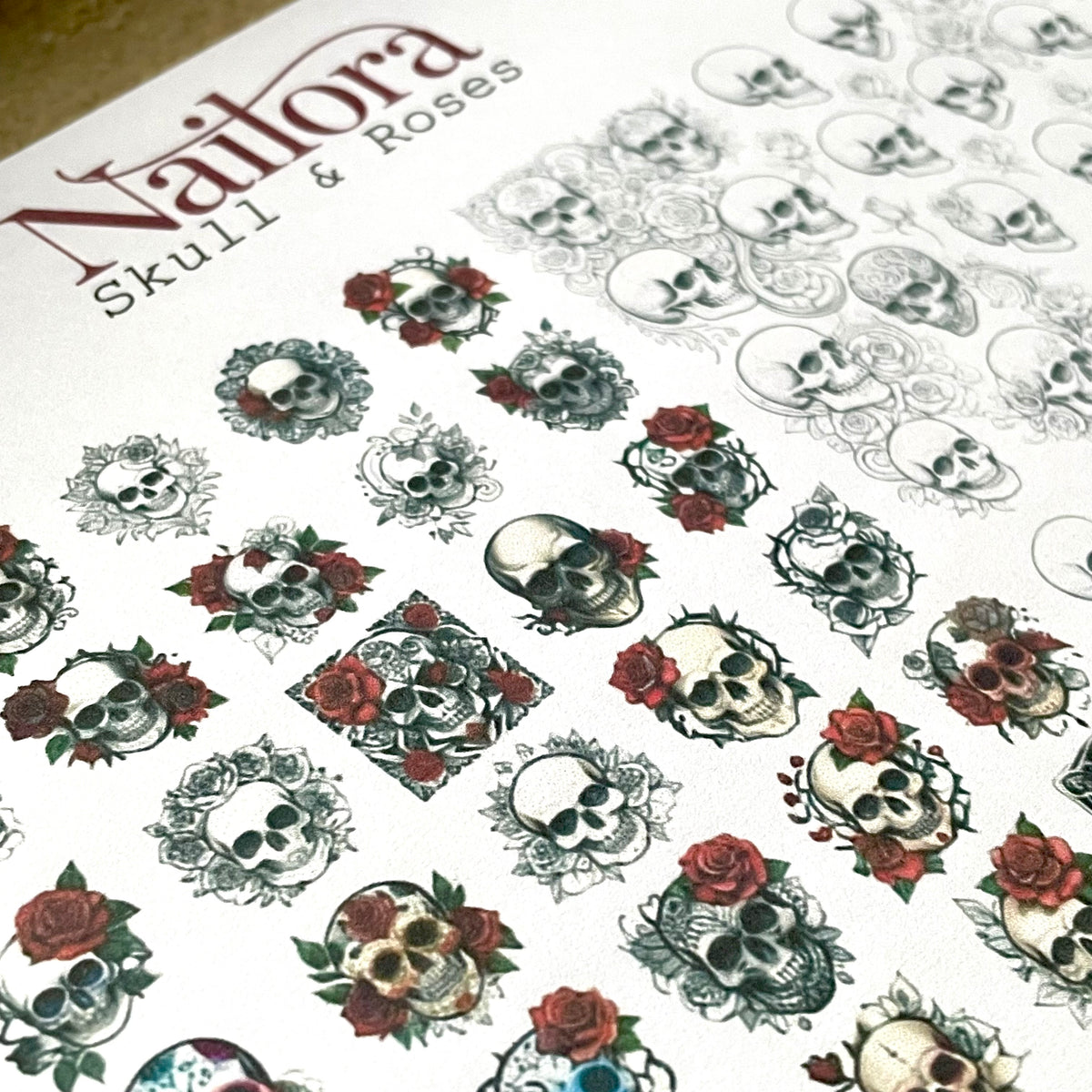 A sheet of decorative nail decals ready to trace and make your own decal stickers featuring skull and rose designs, with the brand name 'Nailora' and text 'Skull & Roses' printed at the top left.