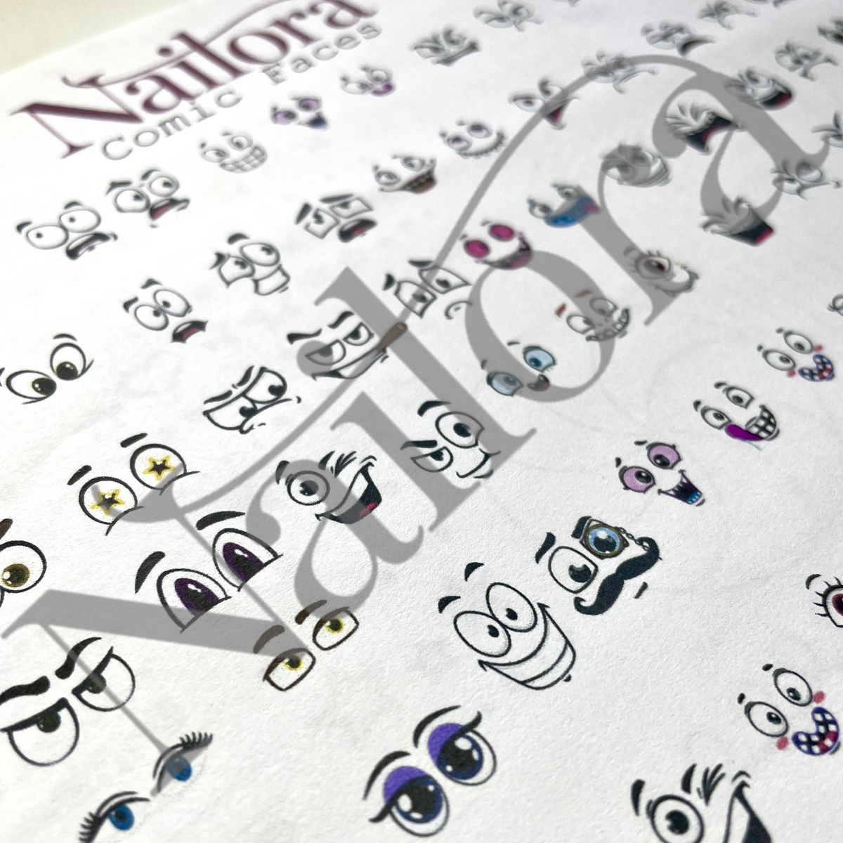 A close-up of a Nailora Comic Faces nail art  sheet on a white background, showing various cartoon face designs with eyes, mustaches, and colorful accents. A large translucent Nailora watermark is overlaid diagonally across the sheet.