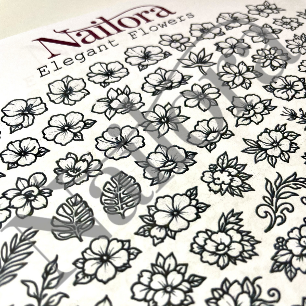 elegant flowers 5 nail art sheet with water mark Nailora across a page of black outline flowers