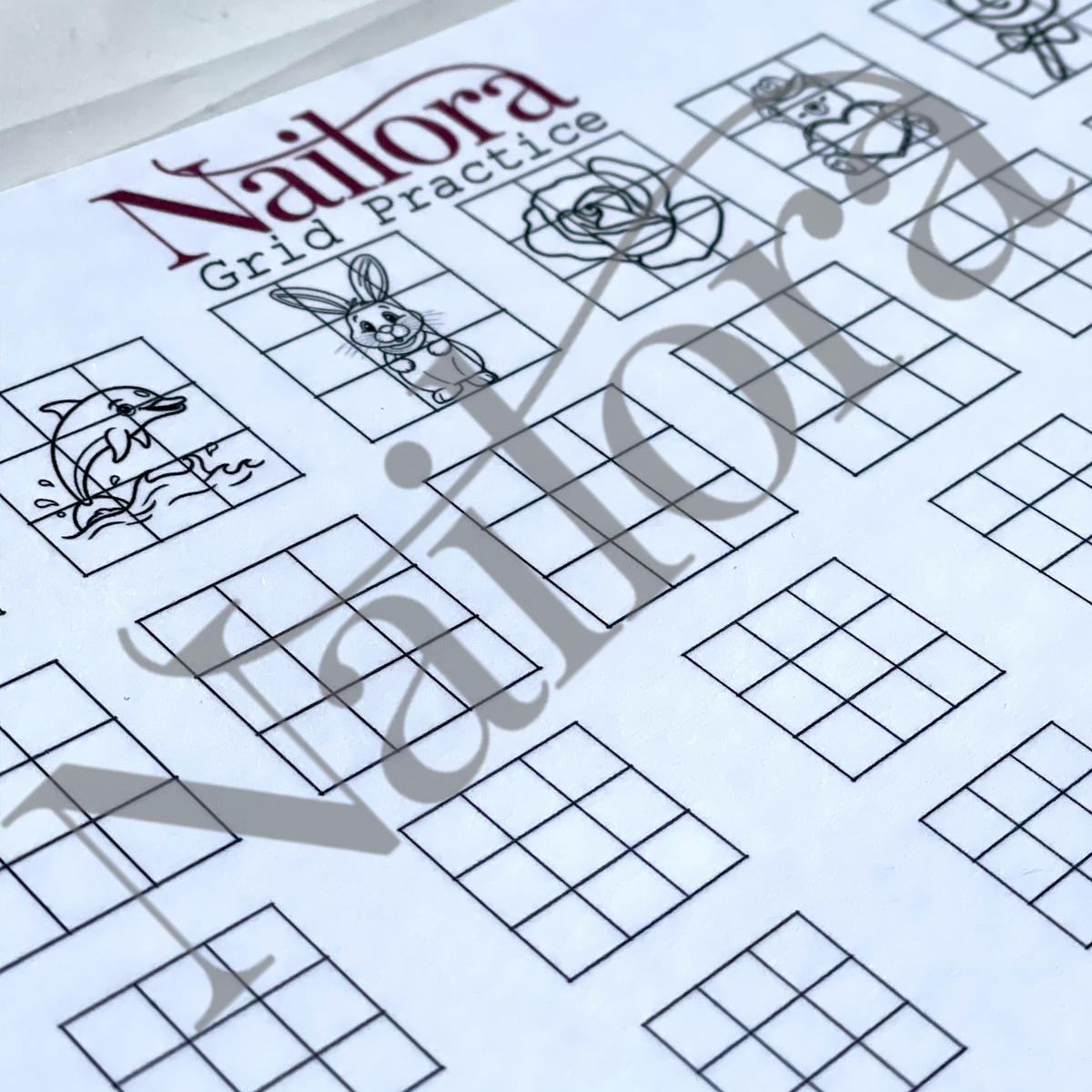 A close-up of a printed Nailora grid practice sheet with black line-art motifs such as a rabbit, fish, and flower over a white background, with a large translucent Nailora watermark across the page.