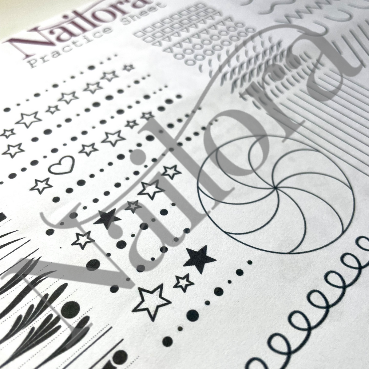 A close-up of a nail practice sheet featuring black geometric and decorative line patterns, including stars, dots, hearts, and wavy lines, with a large translucent watermark reading 'Nailora' across the image.